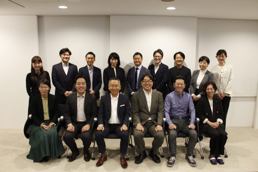 集合写真。複数人が並んで撮影されたオフィス内の様子